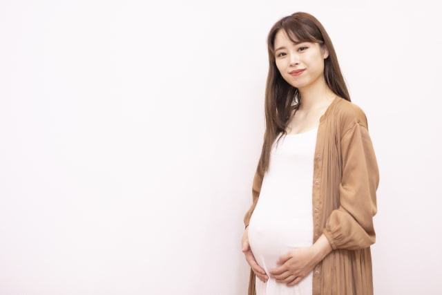 お腹に手を当てる妊娠中の女性